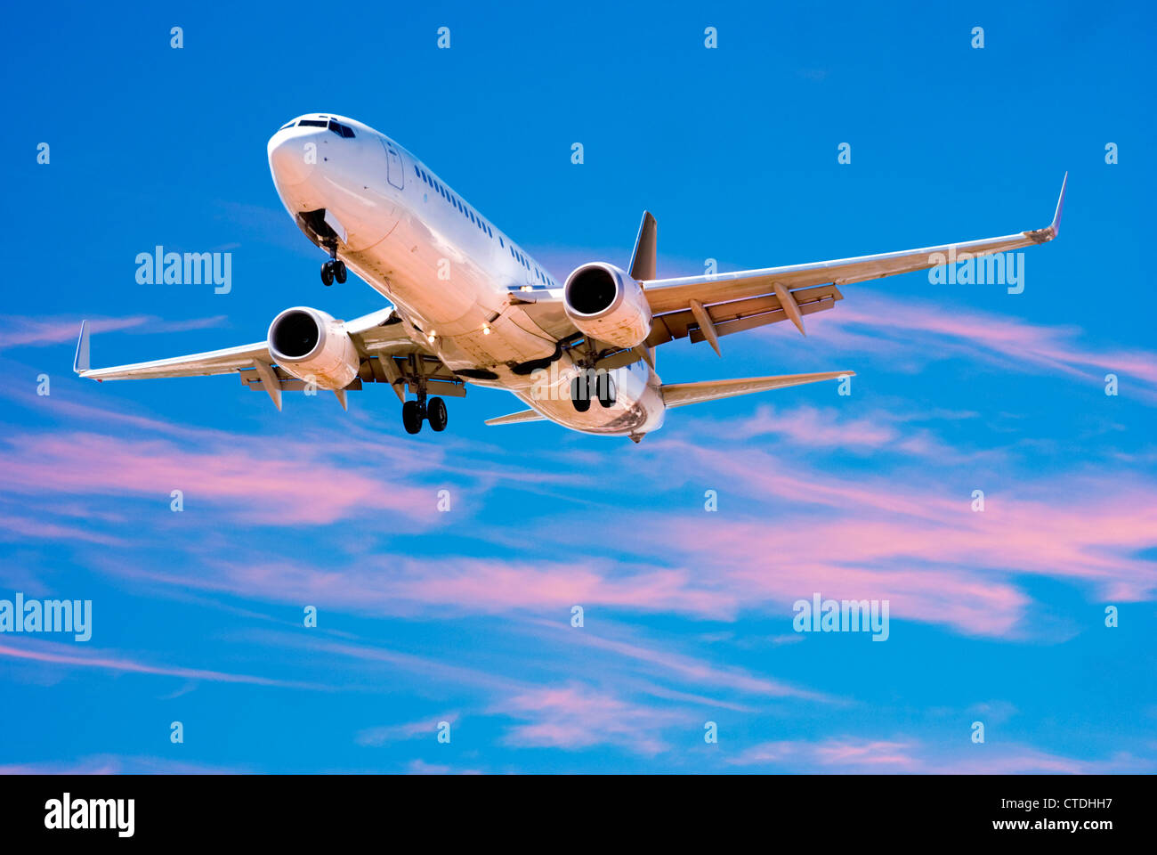 Boeing 737 landing from bright twilight sky. Stock Photo