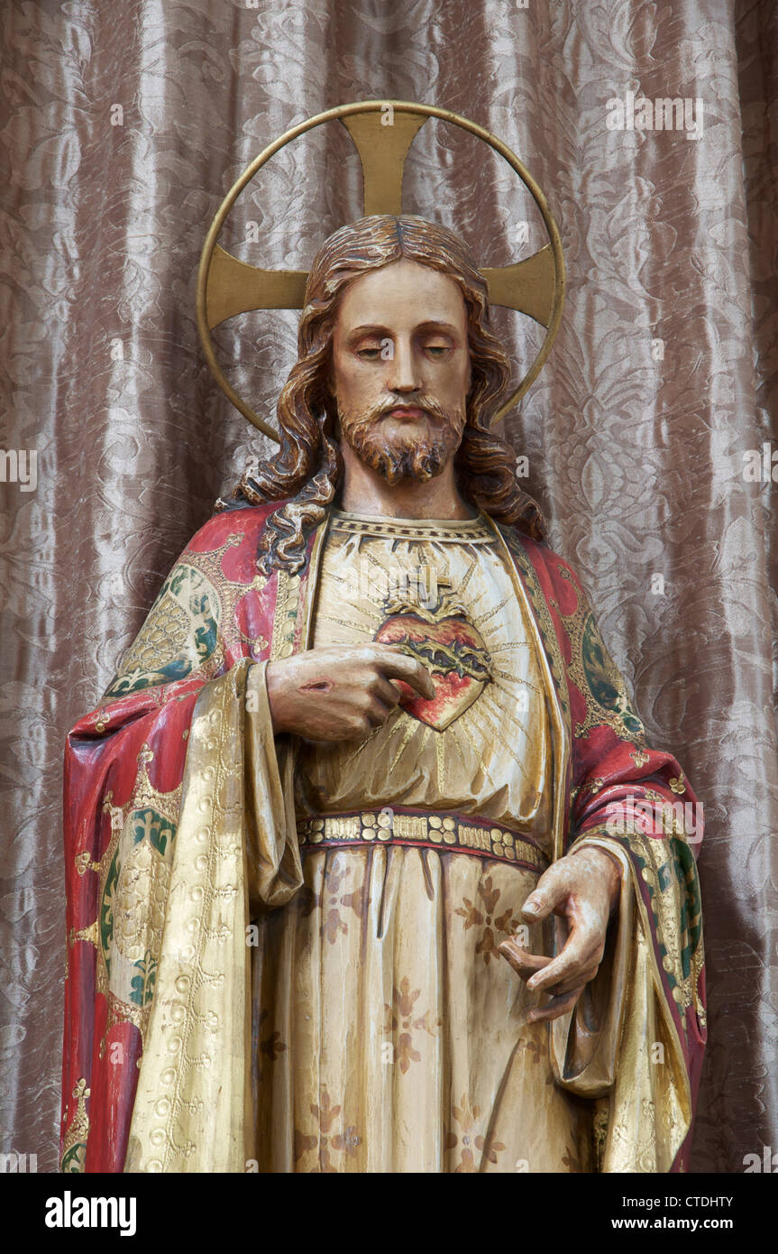Christianity A Statuette Of Jesus Christ In This Traditional Roman Catholic Representation His Wounded Hand Points To The Symbolic Sacred Heart Stock Photo Alamy