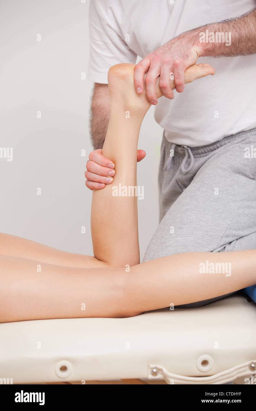 A doctor manipulating the ankle of his patient Stock Photo - Alamy
