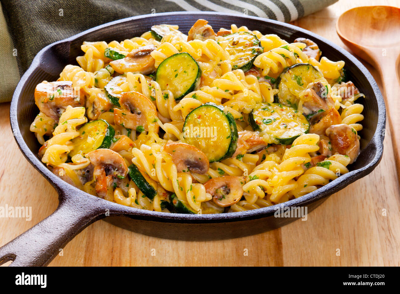 Fusili pasta baked with mushrooms and zucchini in a cream sauce with parmesan, mozzarella and fesh herbs. Stock Photo
