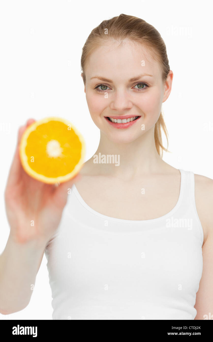 Woman holding an orange while smiling Stock Photo - Alamy