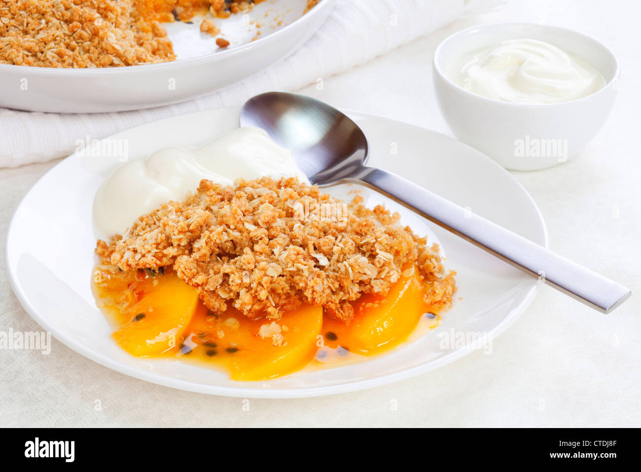 An unusual fruit crumble with peach and passion fruit. The crumble contains wholemeal flour, brown sugar and oats. Stock Photo
