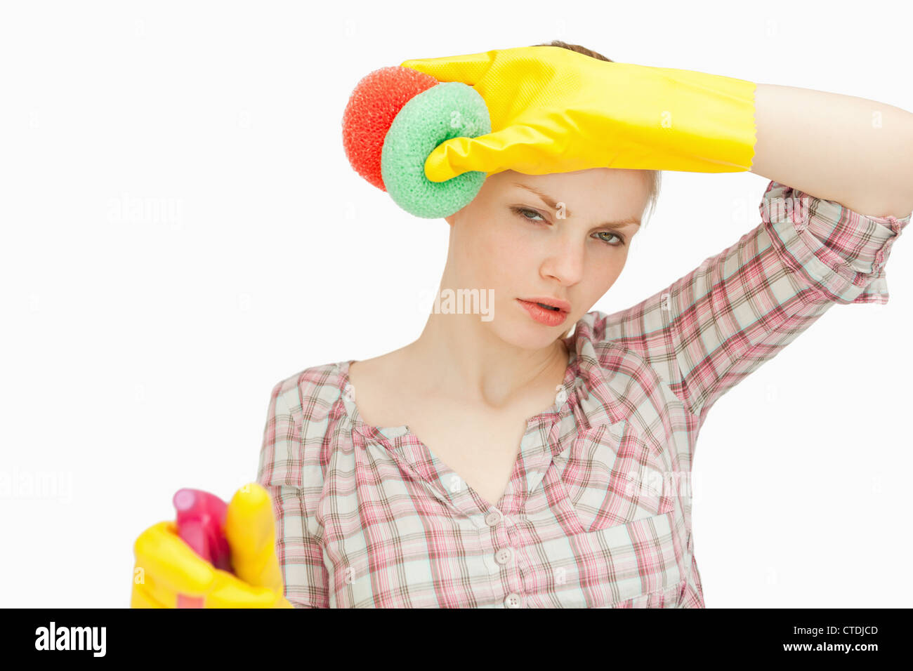 Woman wiping her frown while wearing cleaning gloves Stock Photo