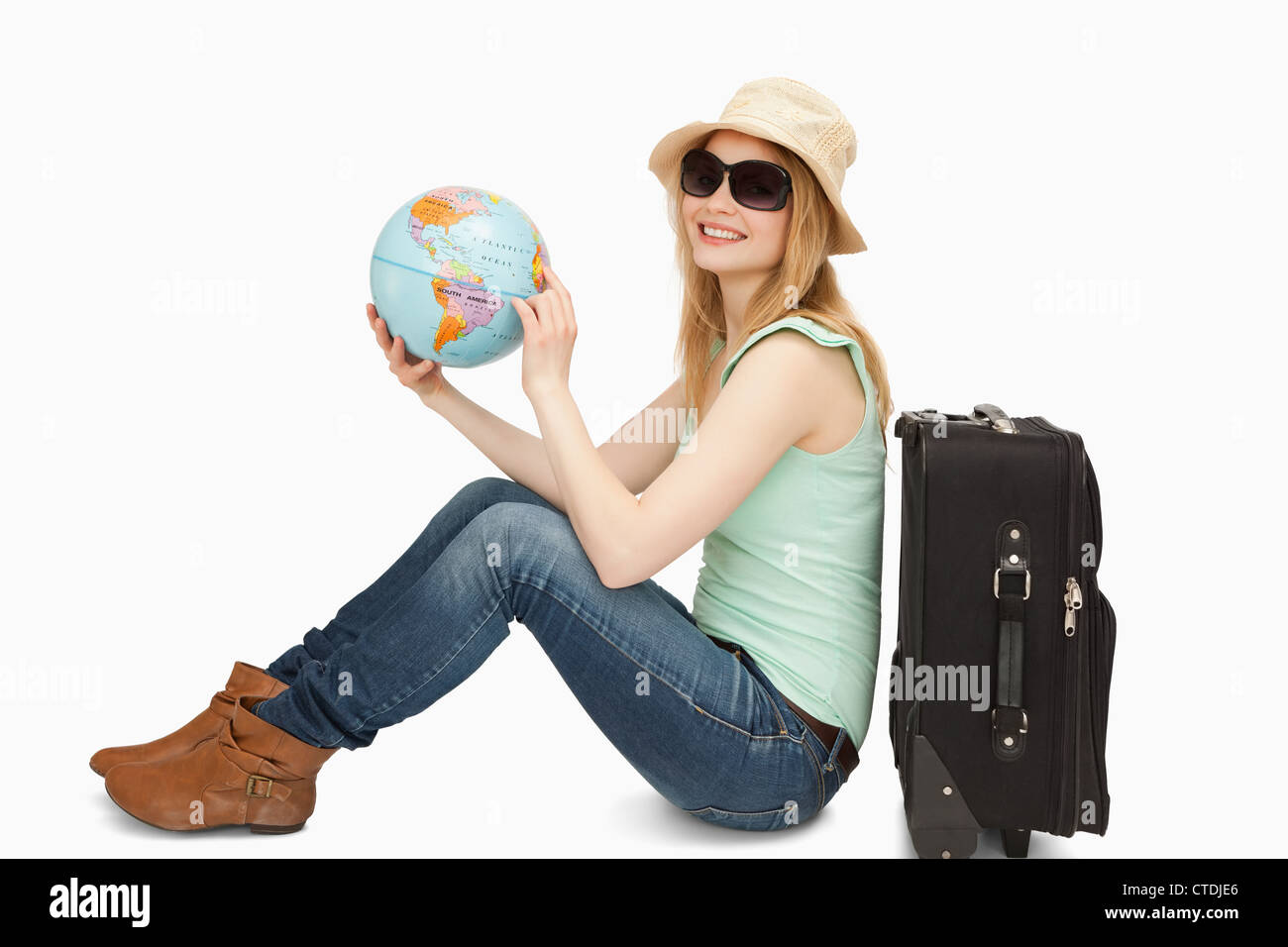 Woman holding a world globe while smiling Stock Photo