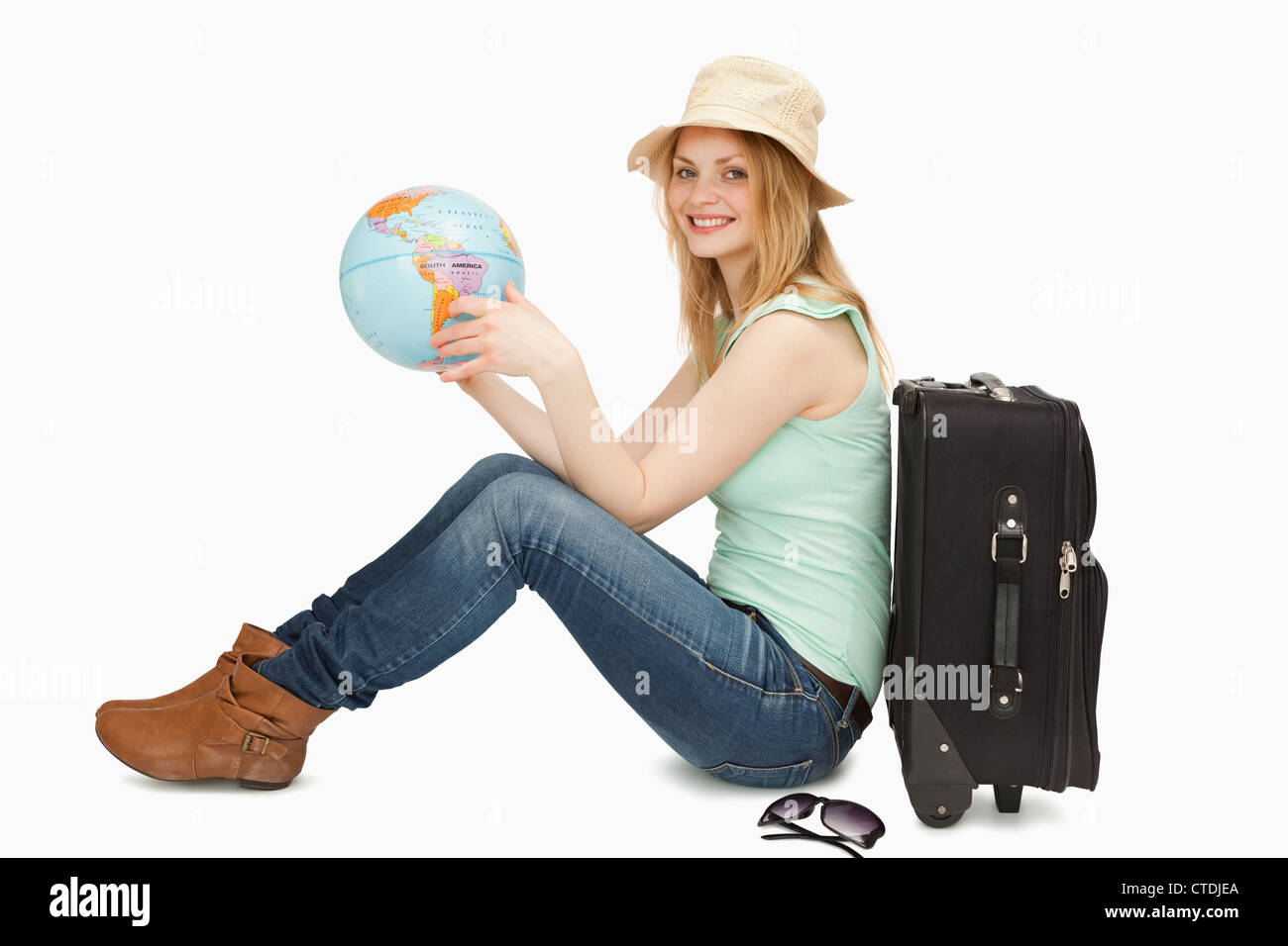 Woman smiling while holding a world globe Stock Photo