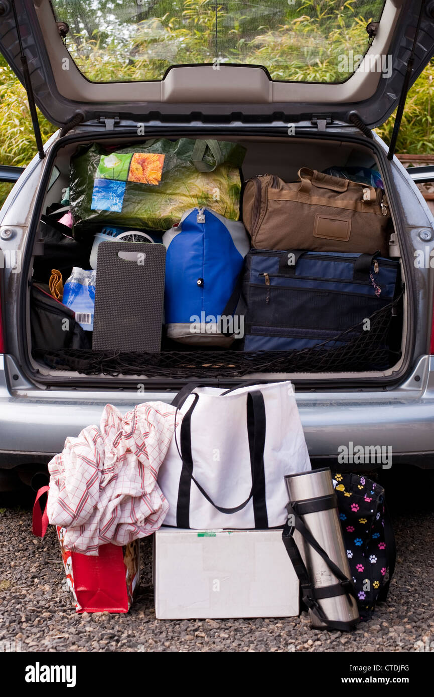 Family on vacation with their automobile packed with suitcases, bags
