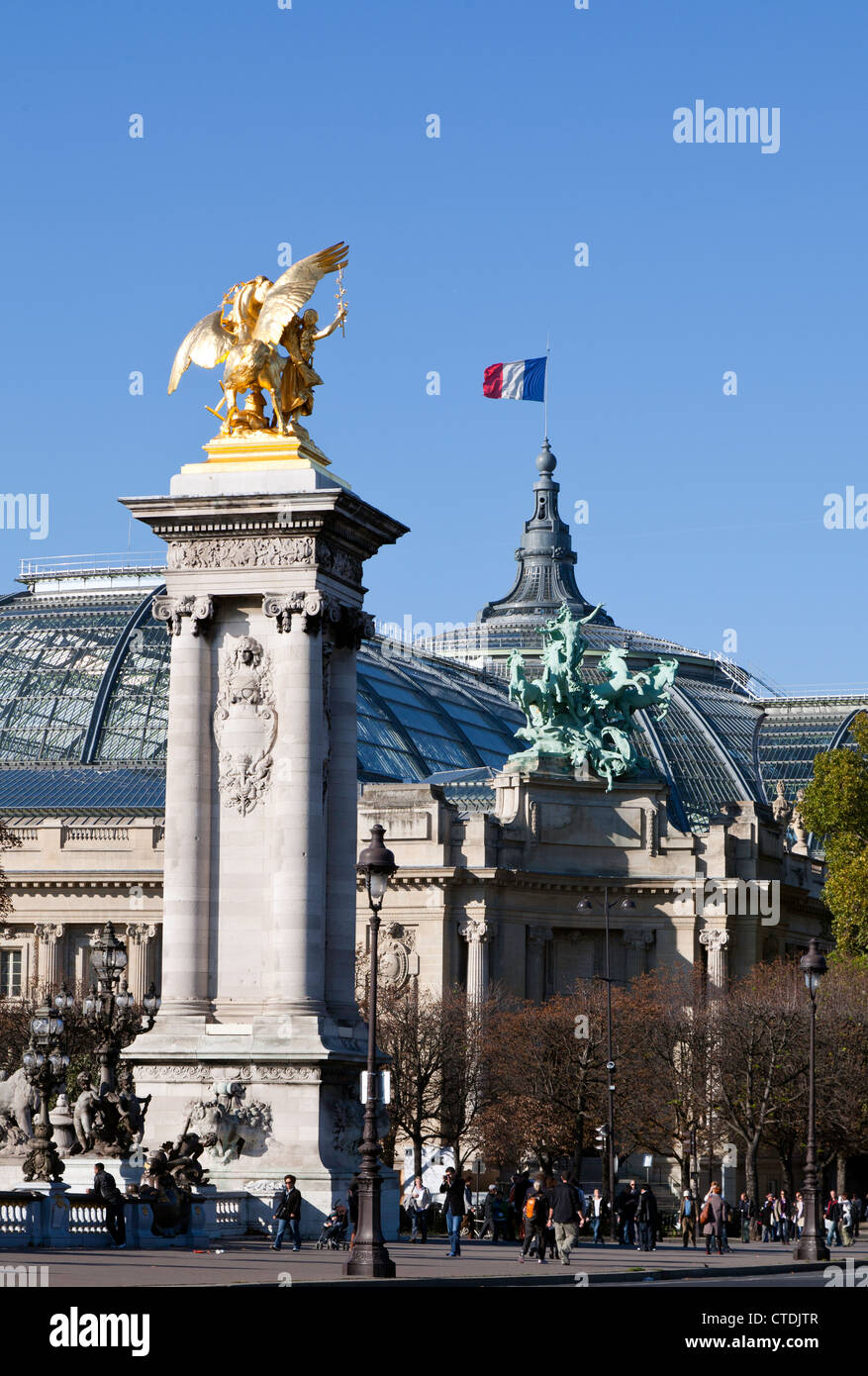 One of the golden statues that line Pont Alexandre II sets the scene for the Grand Palais des Champs-Elysee in background. Stock Photo