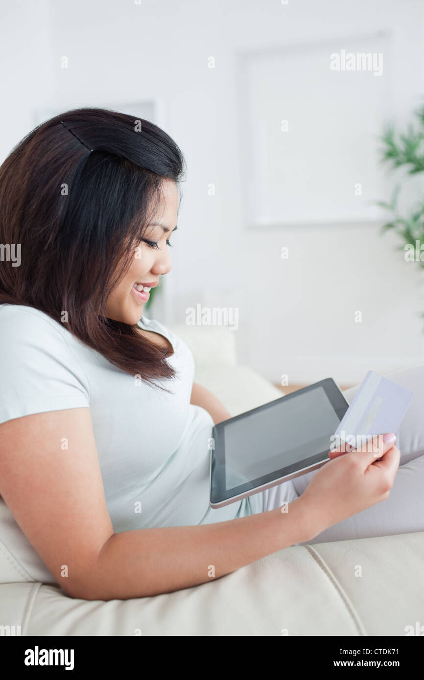 Woman looking at a tactile tablet while sitting on a couch Stock Photo ...