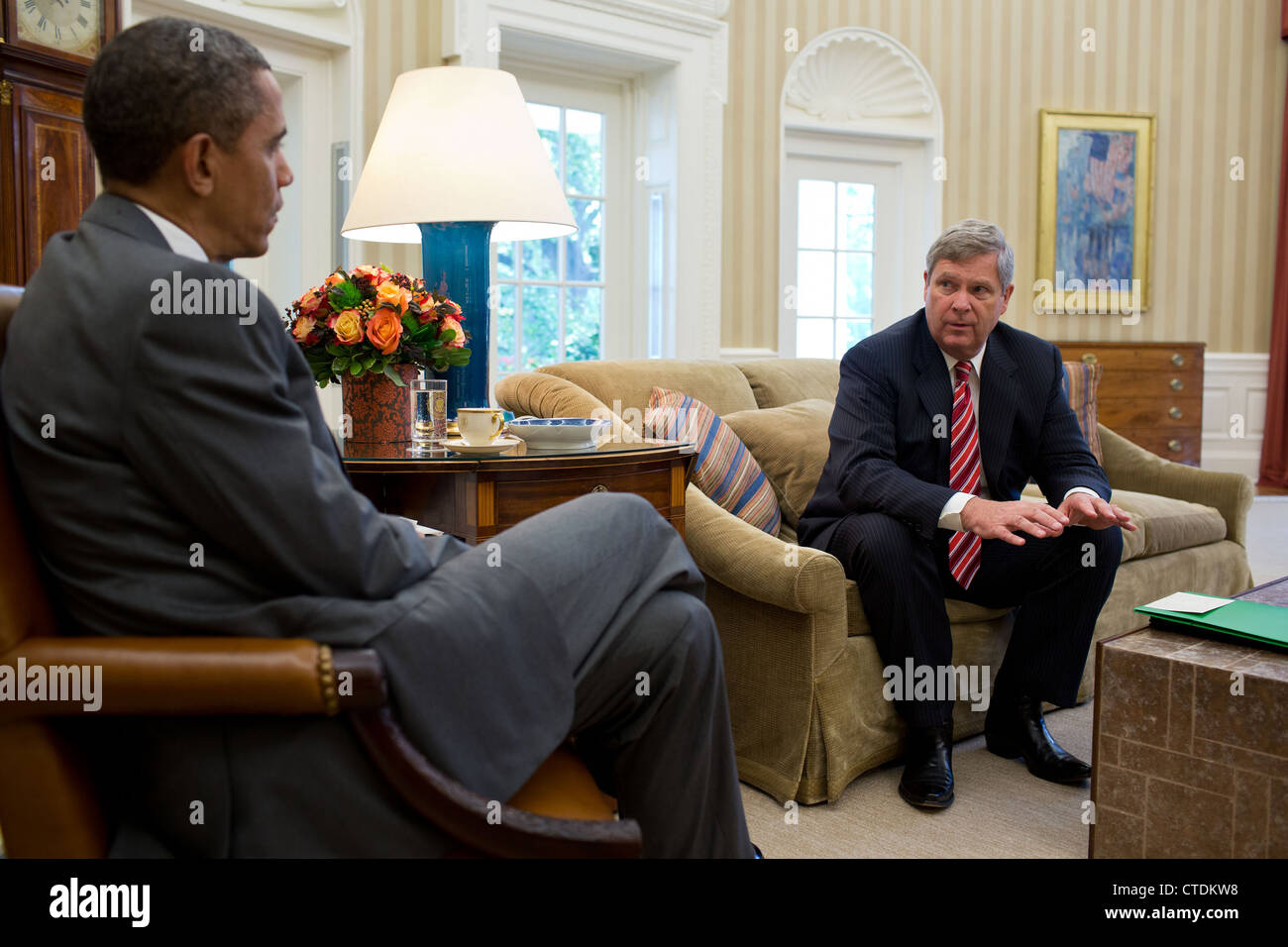 US President Barack Obama is briefed by Agriculture Secretary Tom Vilsack on the Administration’s efforts to respond to the historic drought conditions being felt across the country during a meeting in the Oval Office July 18, 2012 in Washington, DC. Stock Photo