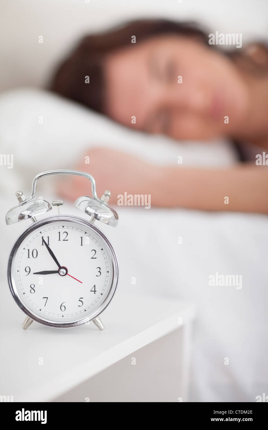Alarm clock being placed on a bedside table Stock Photo