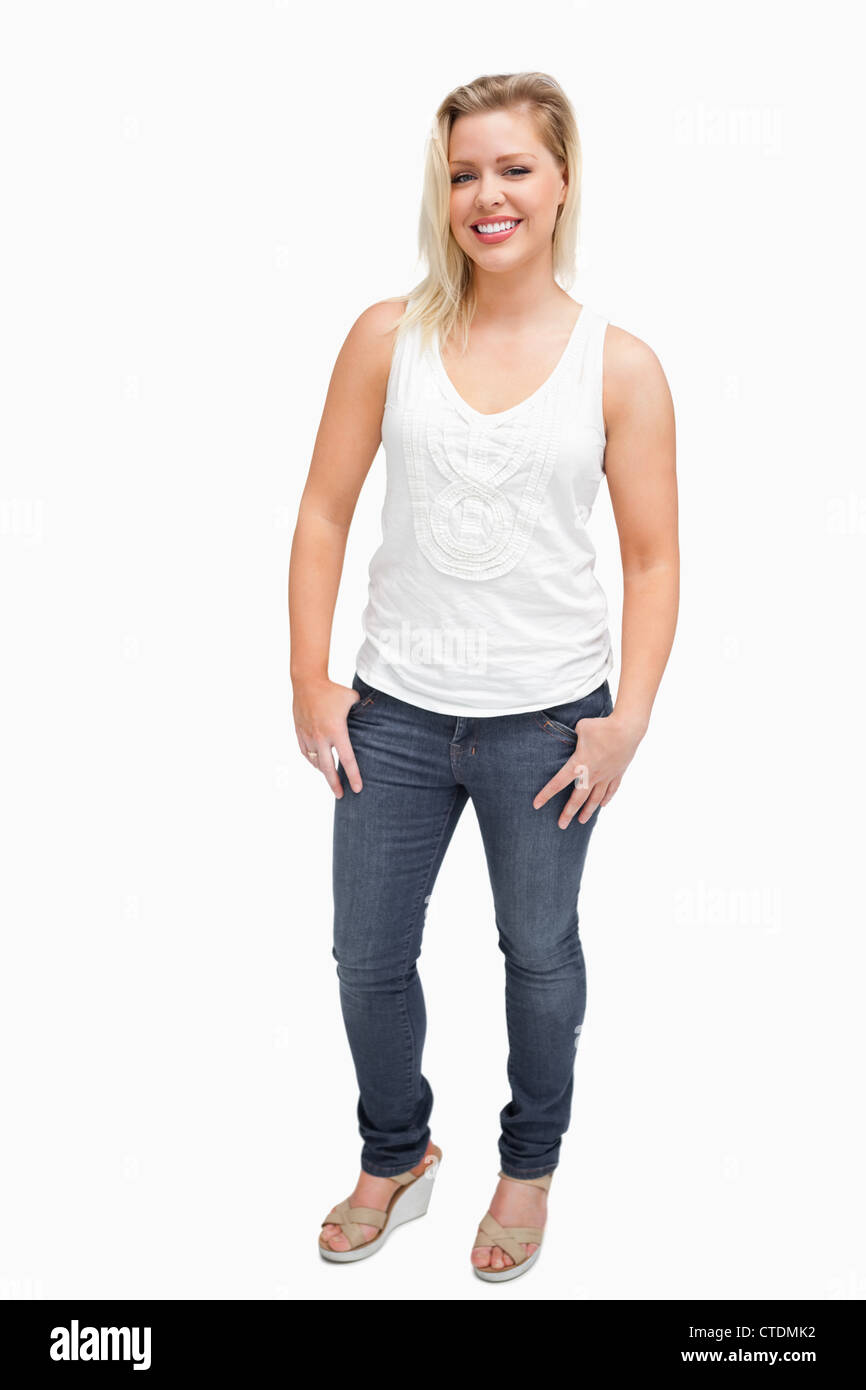 Happy blonde woman standing with her thumbs in her pockets Stock Photo ...