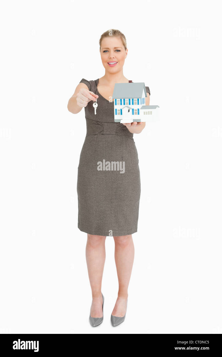 Businesswoman showing a model house and a key Stock Photo - Alamy