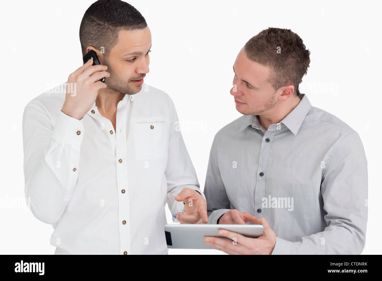 Two people discussing while phoning and holding a tablet computer Stock Photo