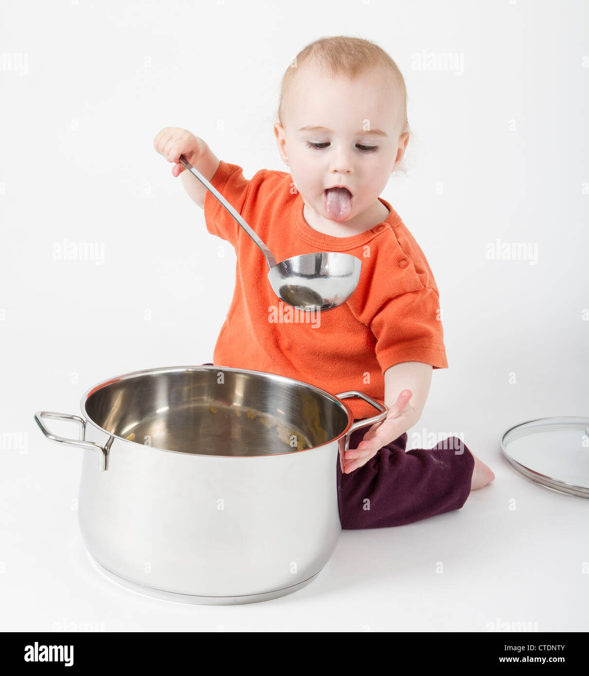baby with big cooking pot isolated on neutral background Stock Photo