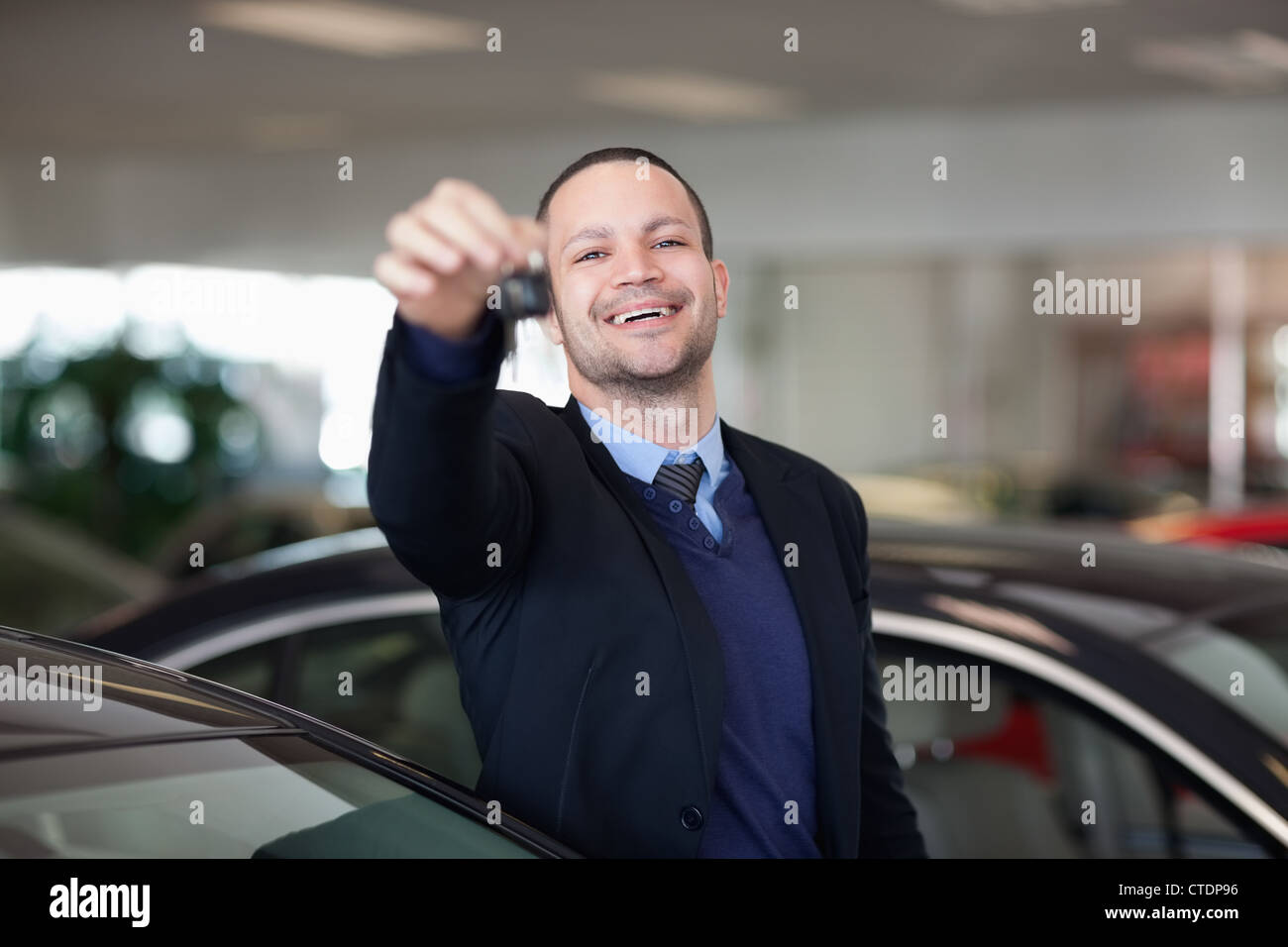 Salesman standing while holding car keys Stock Photo