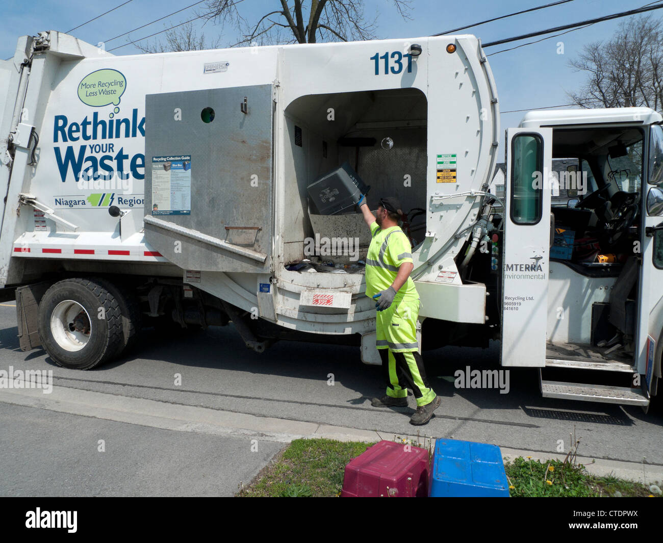 Garbage man loading Rethink Waste truck recycle bin lorry with household recycled paper in the Canadian town of Fort Erie Ontario Canada Stock Photo