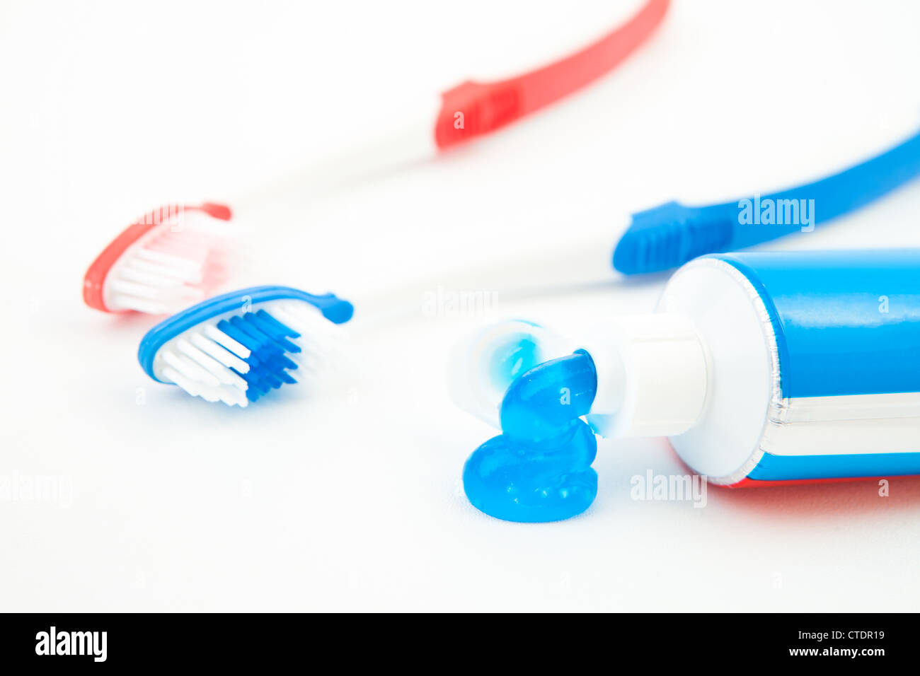 Two toothbrushes next to a tube of toothpaste Stock Photo - Alamy