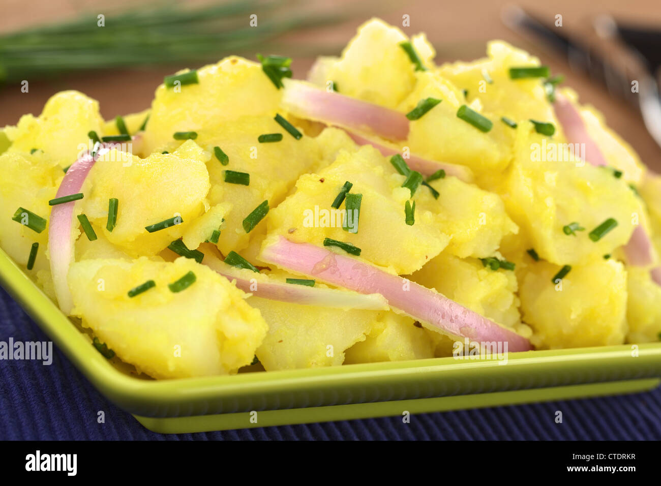 Potato salad with onions prepared in Swabian-Style (Southern Germany) with a vinegar-mustard sauce garnished with chives Stock Photo