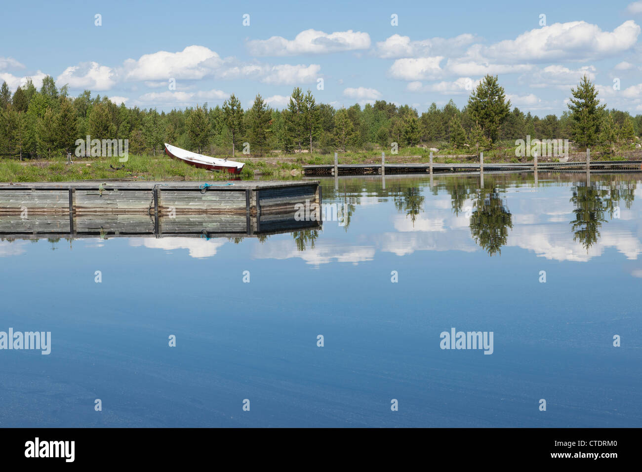 A quiet fishermen's wharf with sunny piers by a lake in Finland Stock Photo