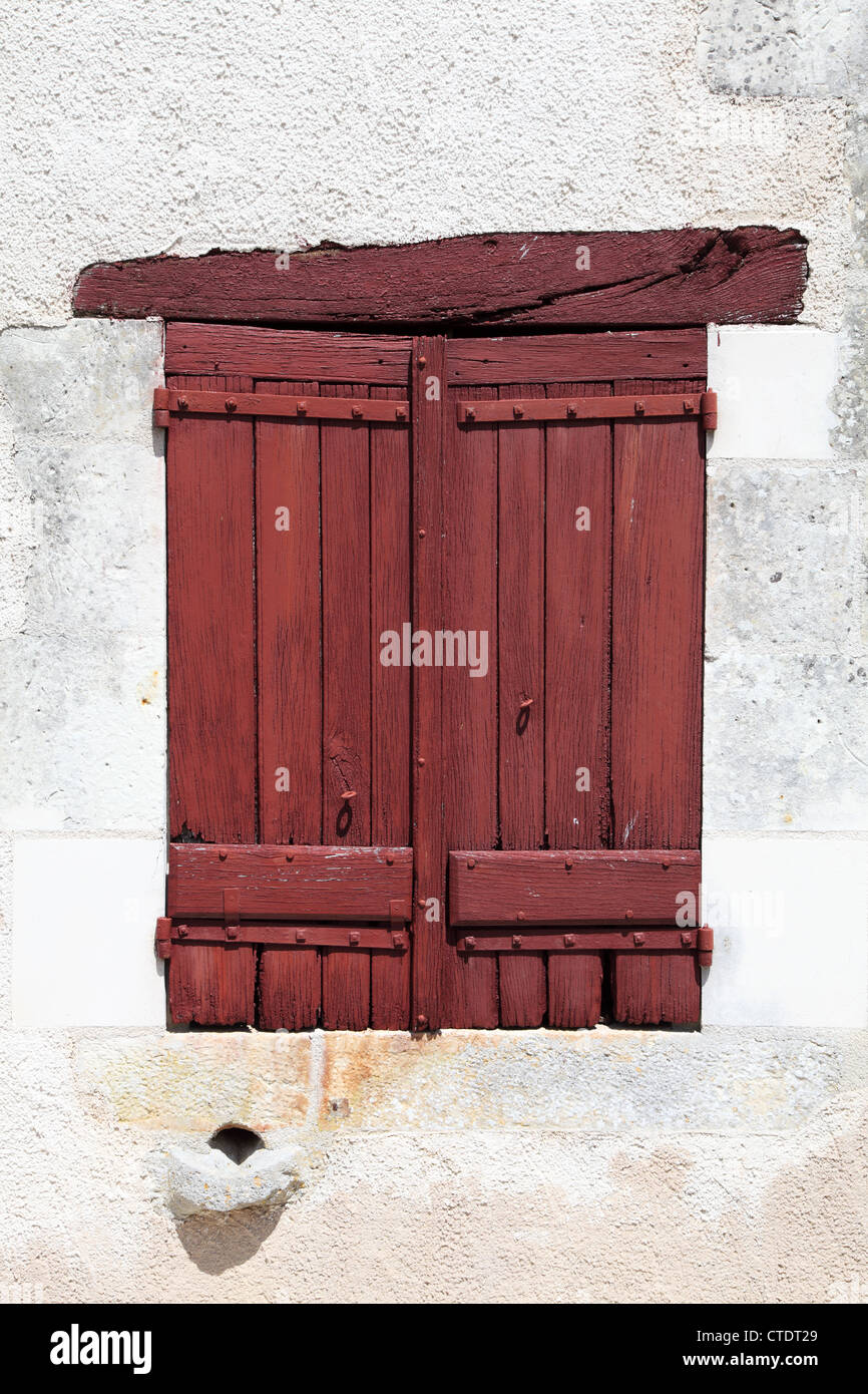 Window with closed red painted wooden shutters Château de Montpoupon France Stock Photo