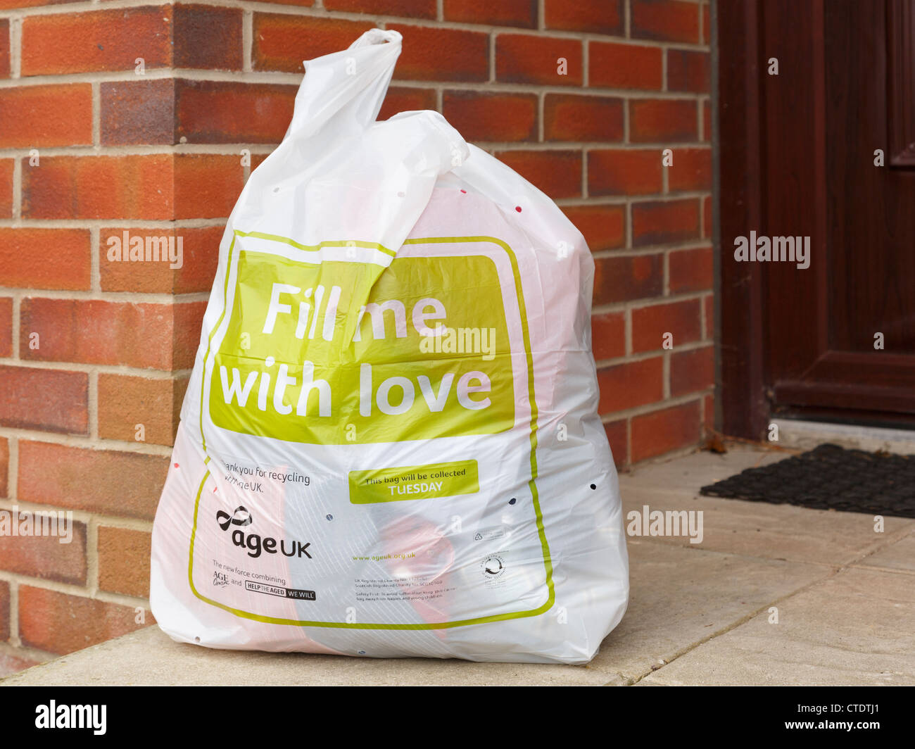 AGE UK charity clothes recycling bag full of old clothing for