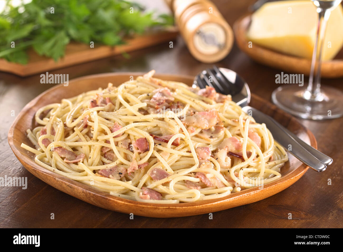 Spaghetti alla Carbonara served on wooden plate (Selective Focus, Focus one third into the meal) Stock Photo