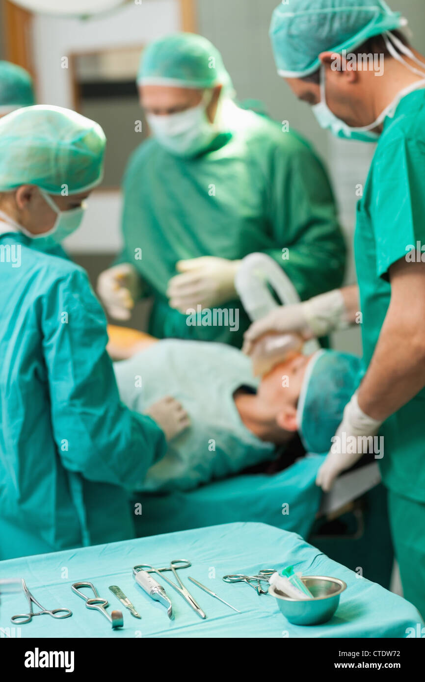 Table full of surgical tools in front of a surgical team working Stock Photo Alamy