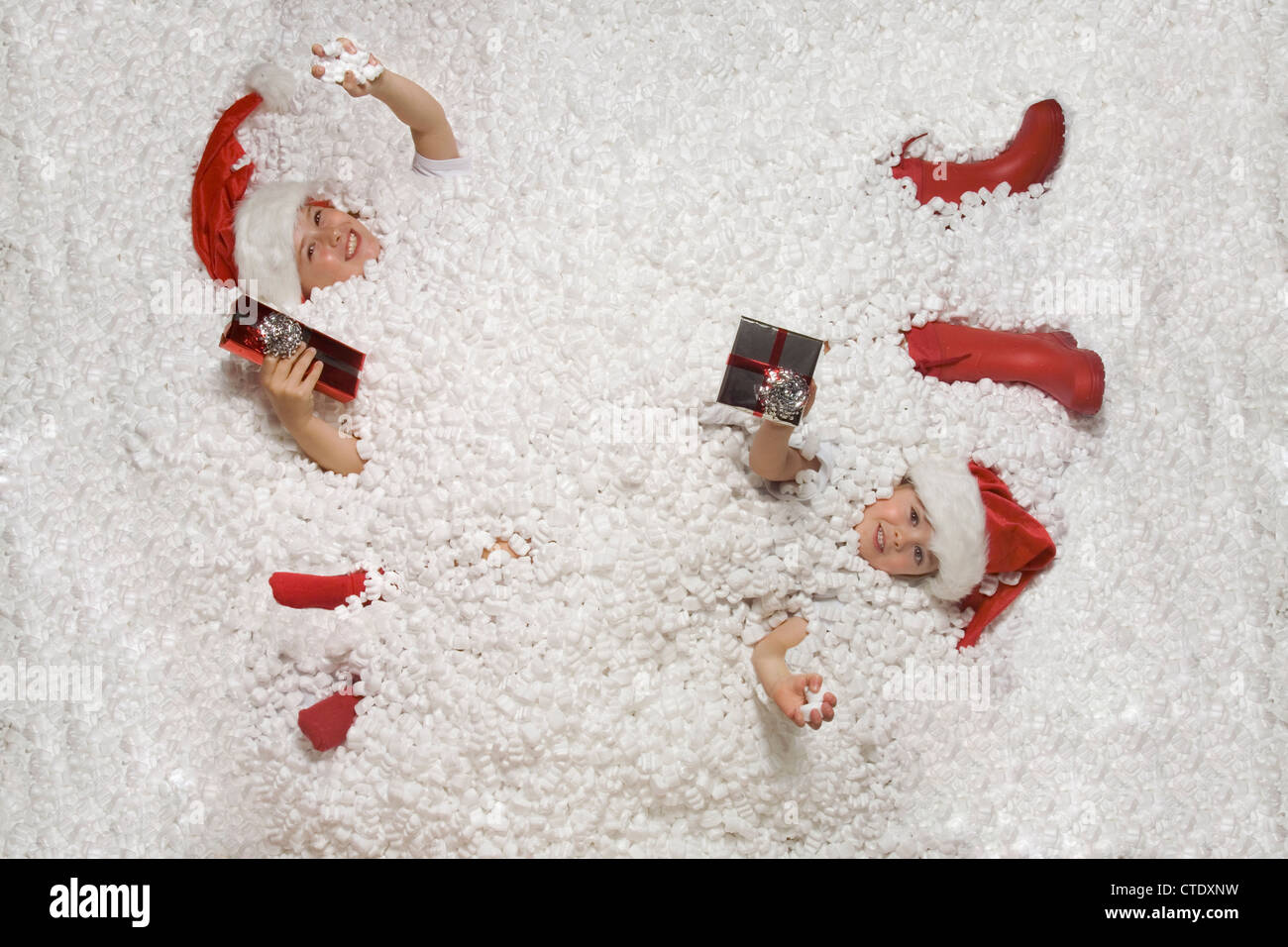 Christmas kids lay in snow with presents happy Stock Photo