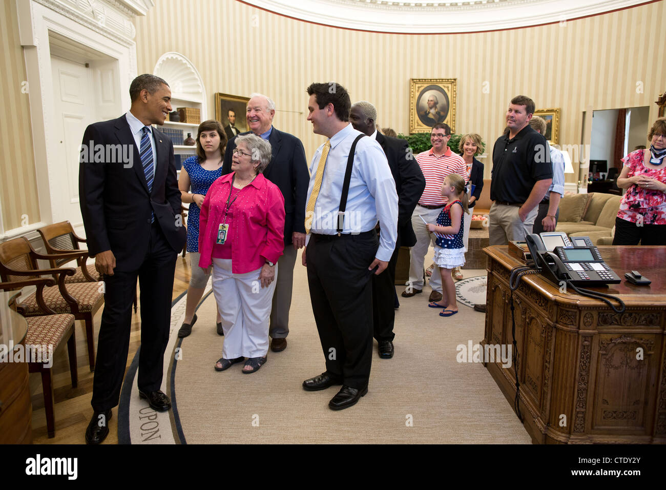 US President Barack Obama gives a tour of the Oval Office to Steve and Kappy Scates and their family, June 27, 2012 in Washington, DC. The Scates were early supporters of the President. Stock Photo