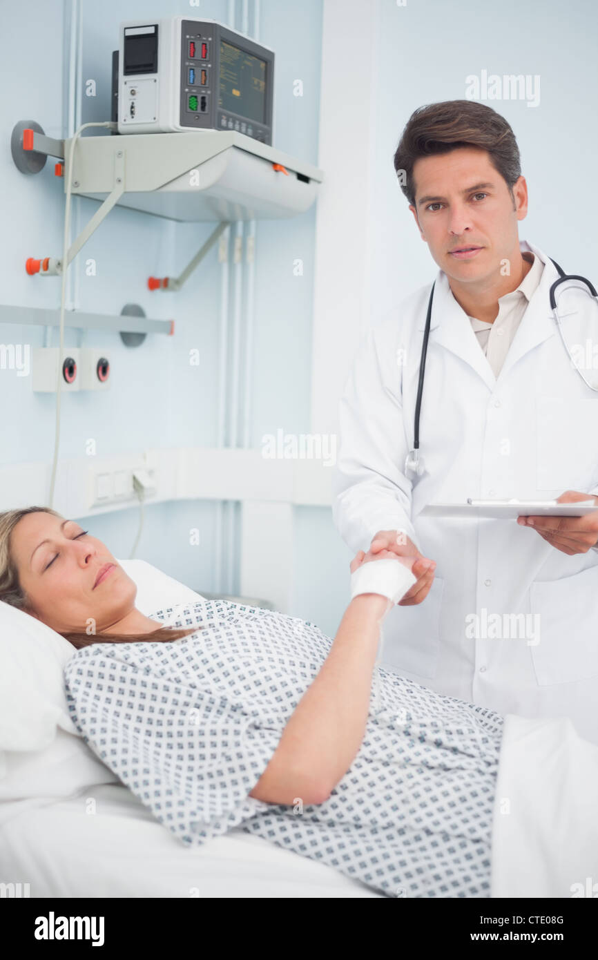 Doctor holding medical results and the hand of his patient Stock Photo Alamy