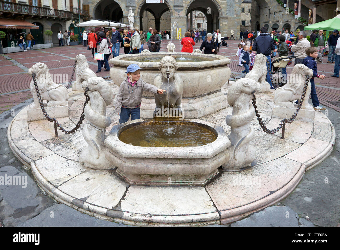 Young boy playing in the Contarini fountain, 1780, Piazza Vecchia, upper city, Bergamo, Lombardy, Italy, Europe Stock Photo