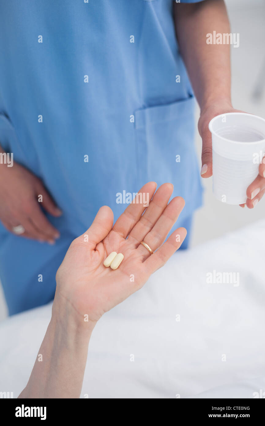 Nurse giving plastic glass to a patient Stock Photo