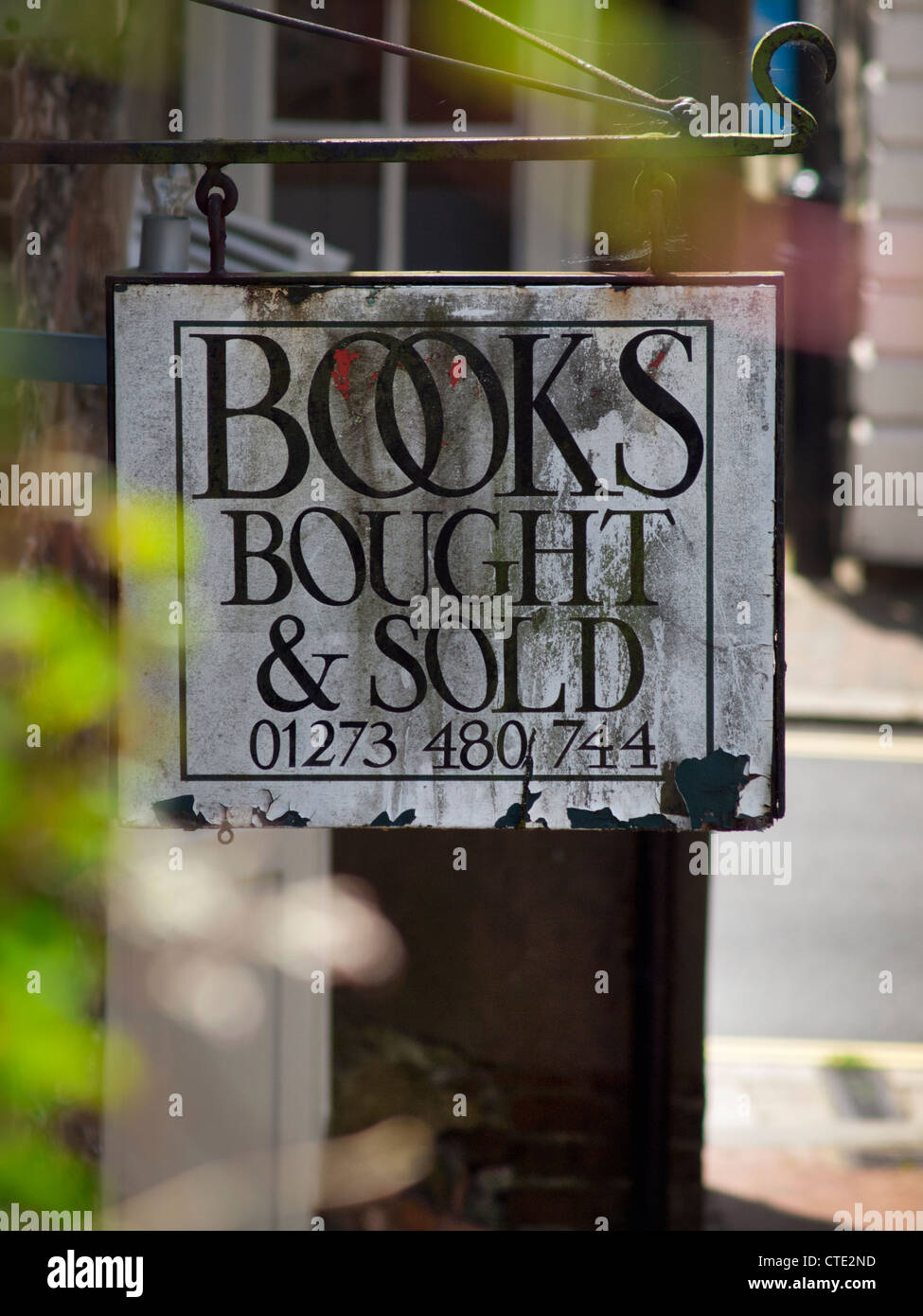 Down an alley in Lewes,East Sussex hangs a sign for a dealer in books. Stock Photo