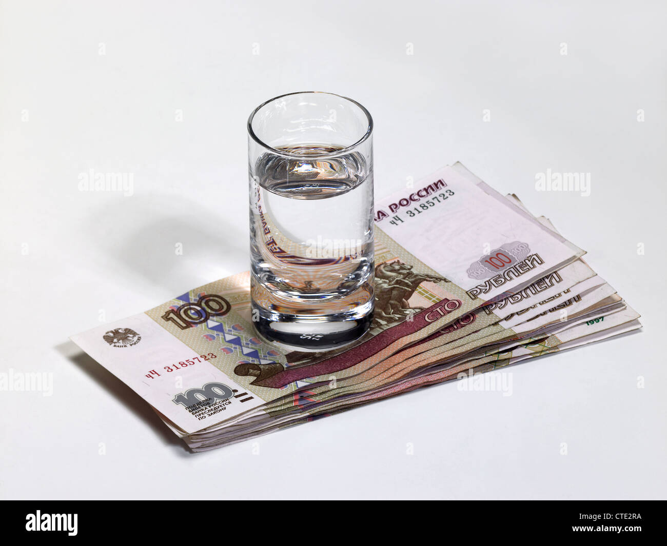 Pile of Russian ruble notes with a glass of vodka Stock Photo