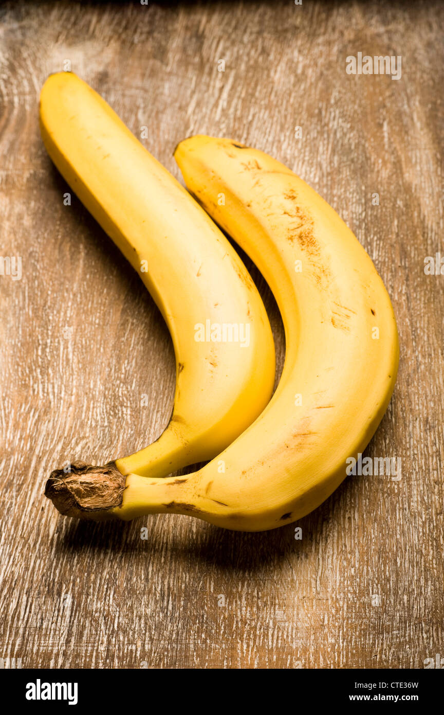 two organic bananas on a wood surface Stock Photo