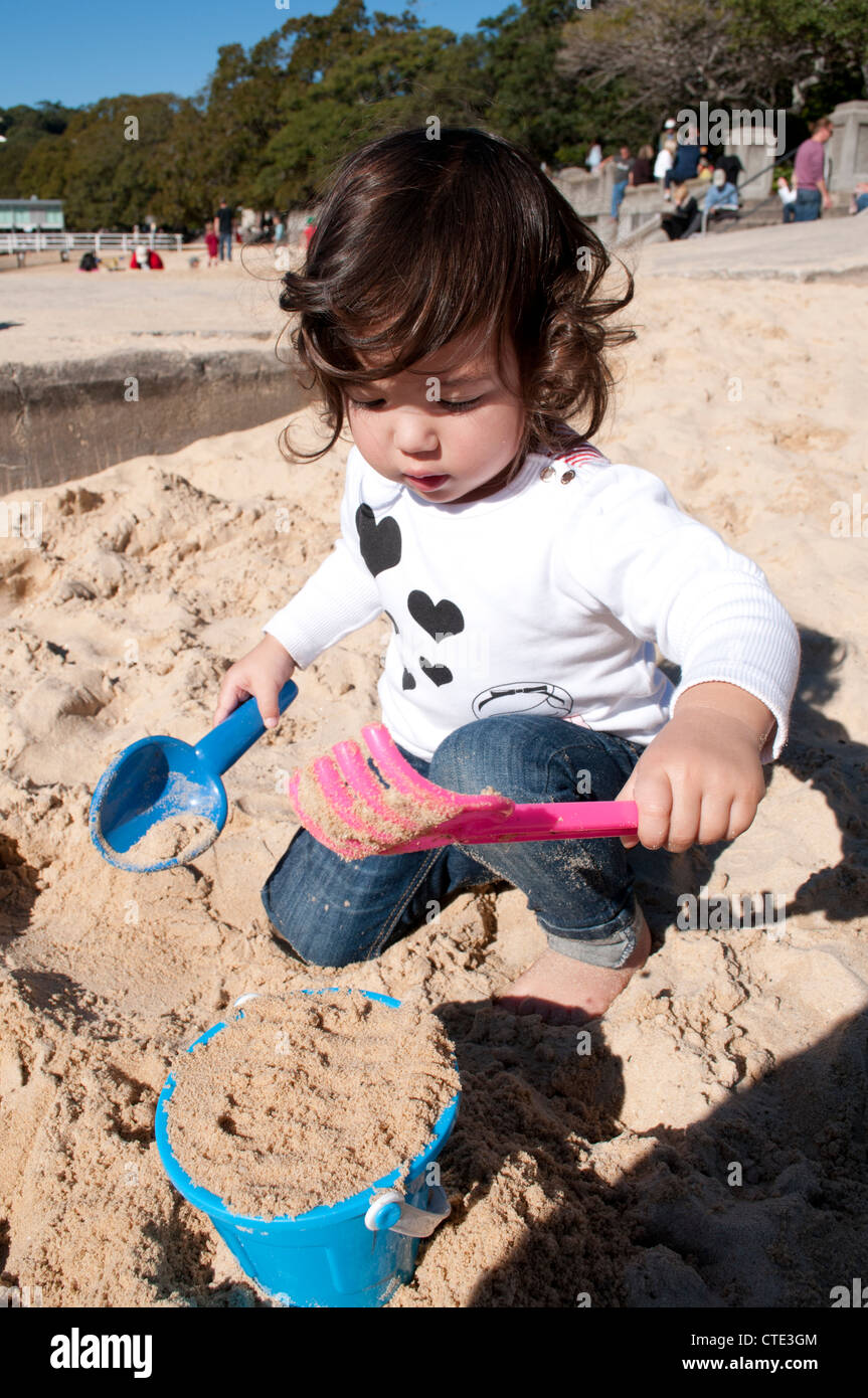 Little girl playing in the sand Stock Photo - Alamy
