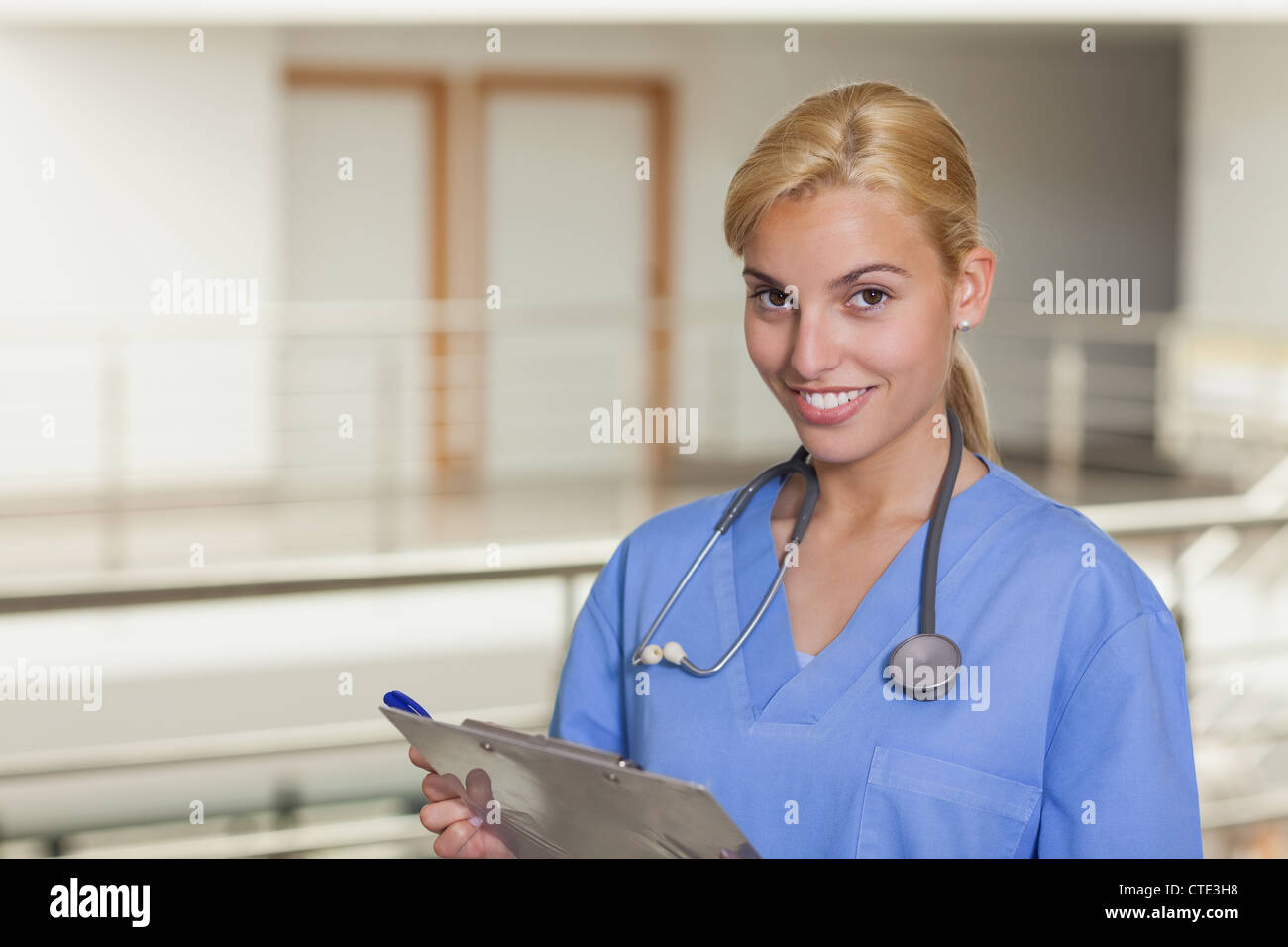 Blonde nurse holding a clipboard Stock Photo - Alamy
