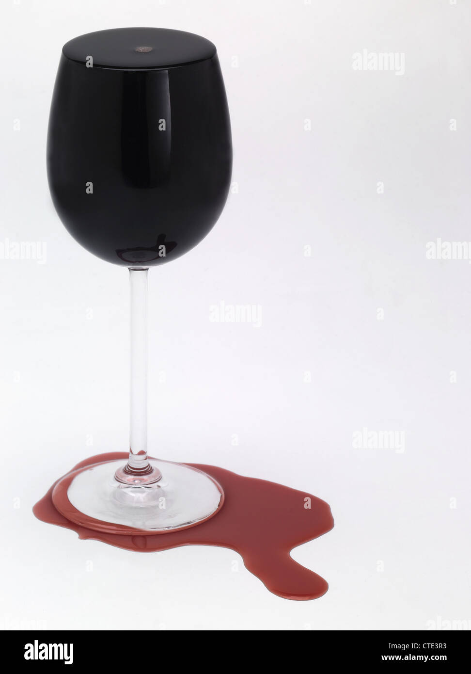 A full glass of red wine spilling over Stock Photo