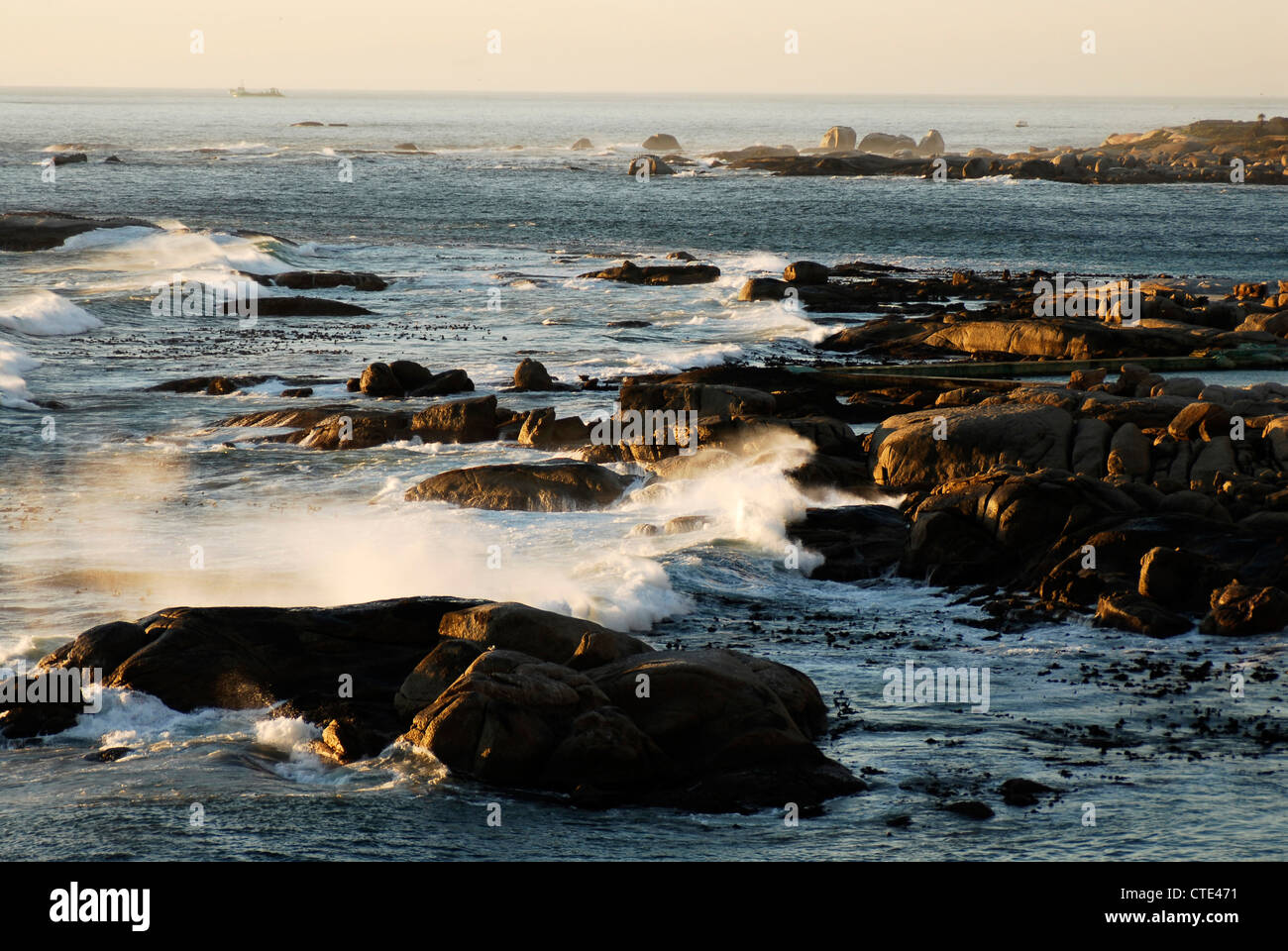 Waves break on rocks at Camps Bay, Cape Town, Western Cape, South Africa Stock Photo