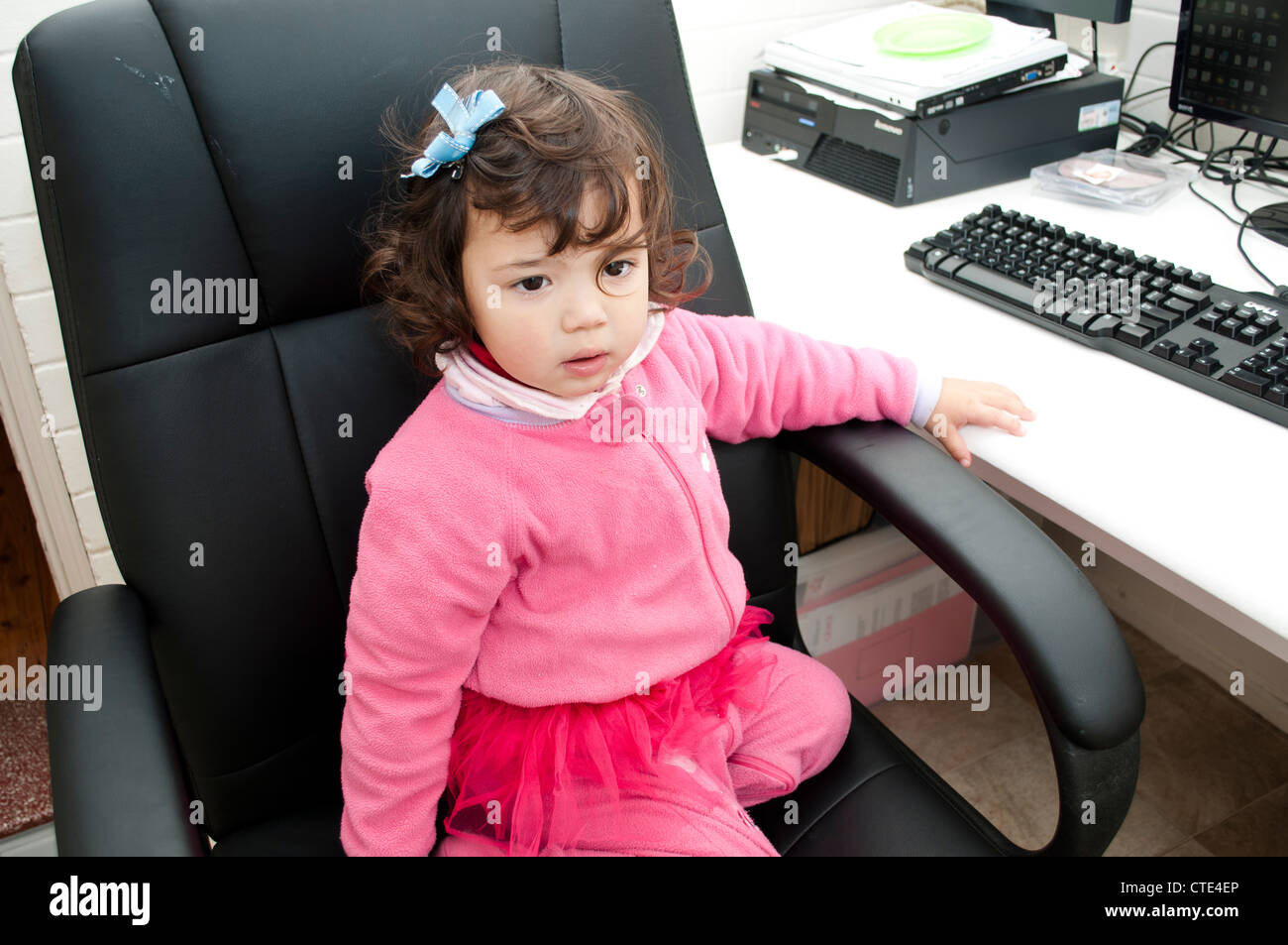 Little girl next to a computer Stock Photo