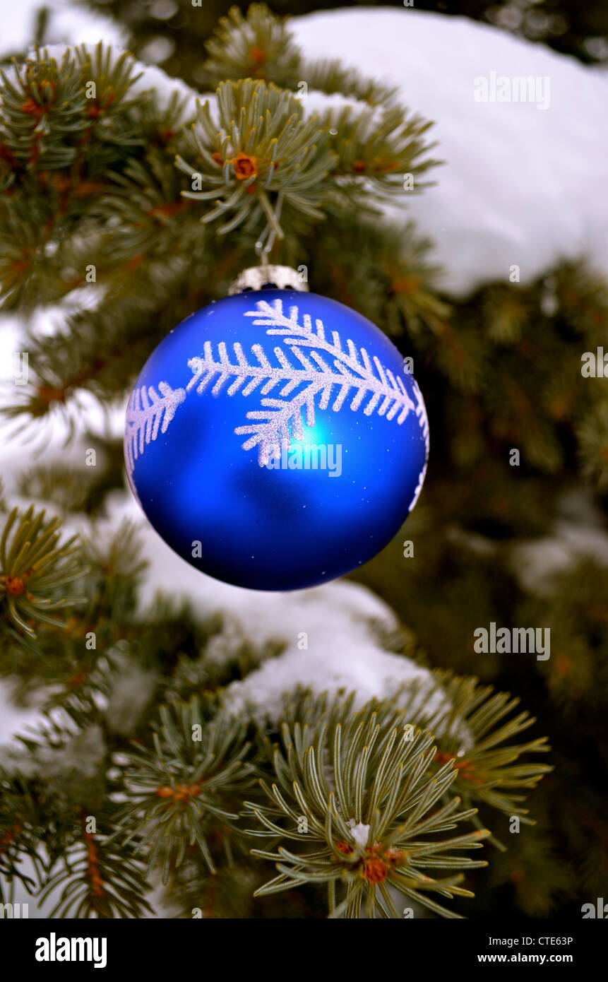 Lone Christmas ornament hanging from a tree outside. Stock Photo
