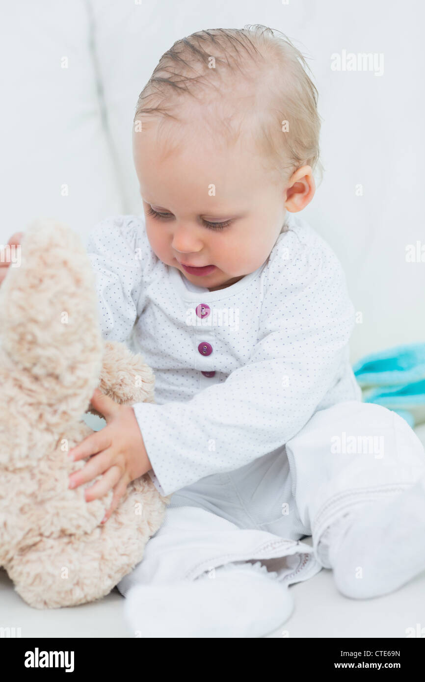 Baby touching a teddy bear Stock Photo Alamy