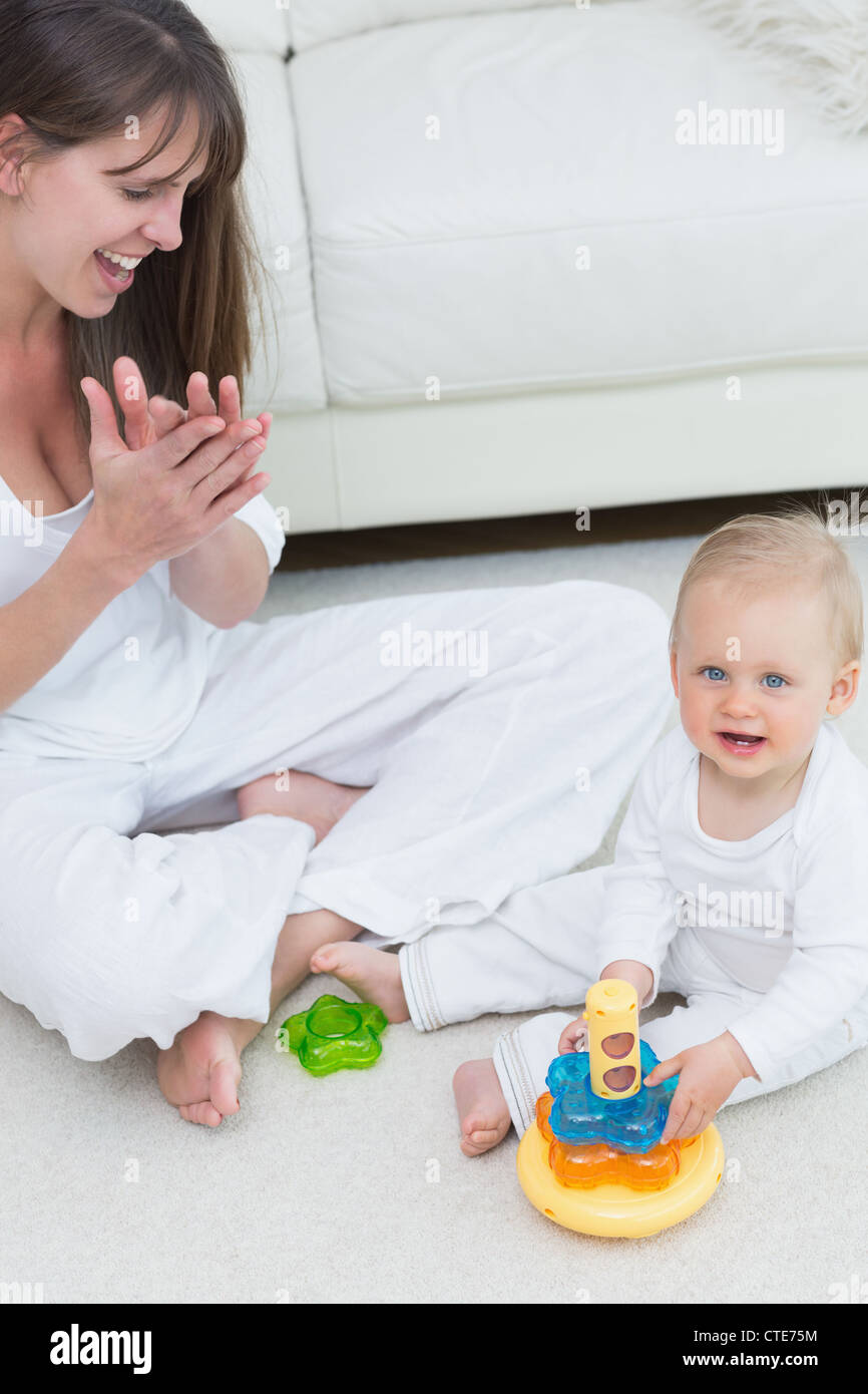 Baby sitting on the floor while playing Stock Photo - Alamy