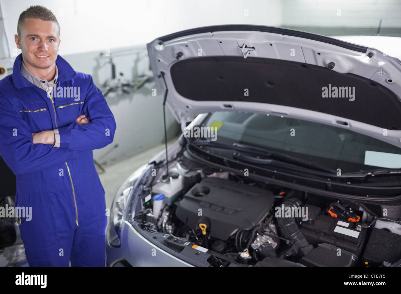 Smiling mechanic next to a car Stock Photo - Alamy