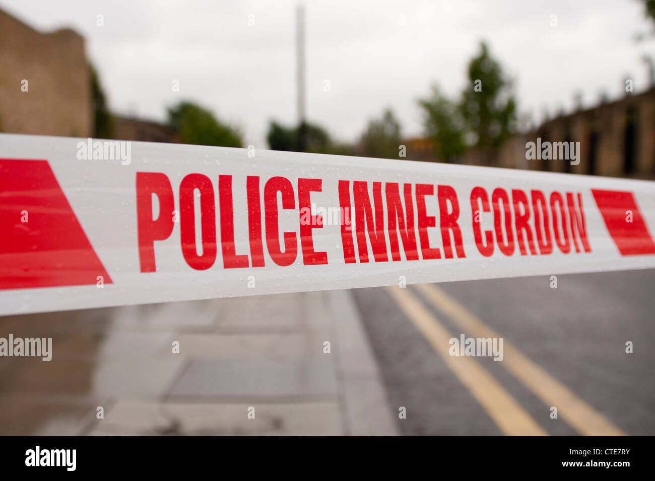 Police tape for crime scene, 'Police Inner cordon'. red on white, generic  blurred background with double yellow lines Stock Photo - Alamy