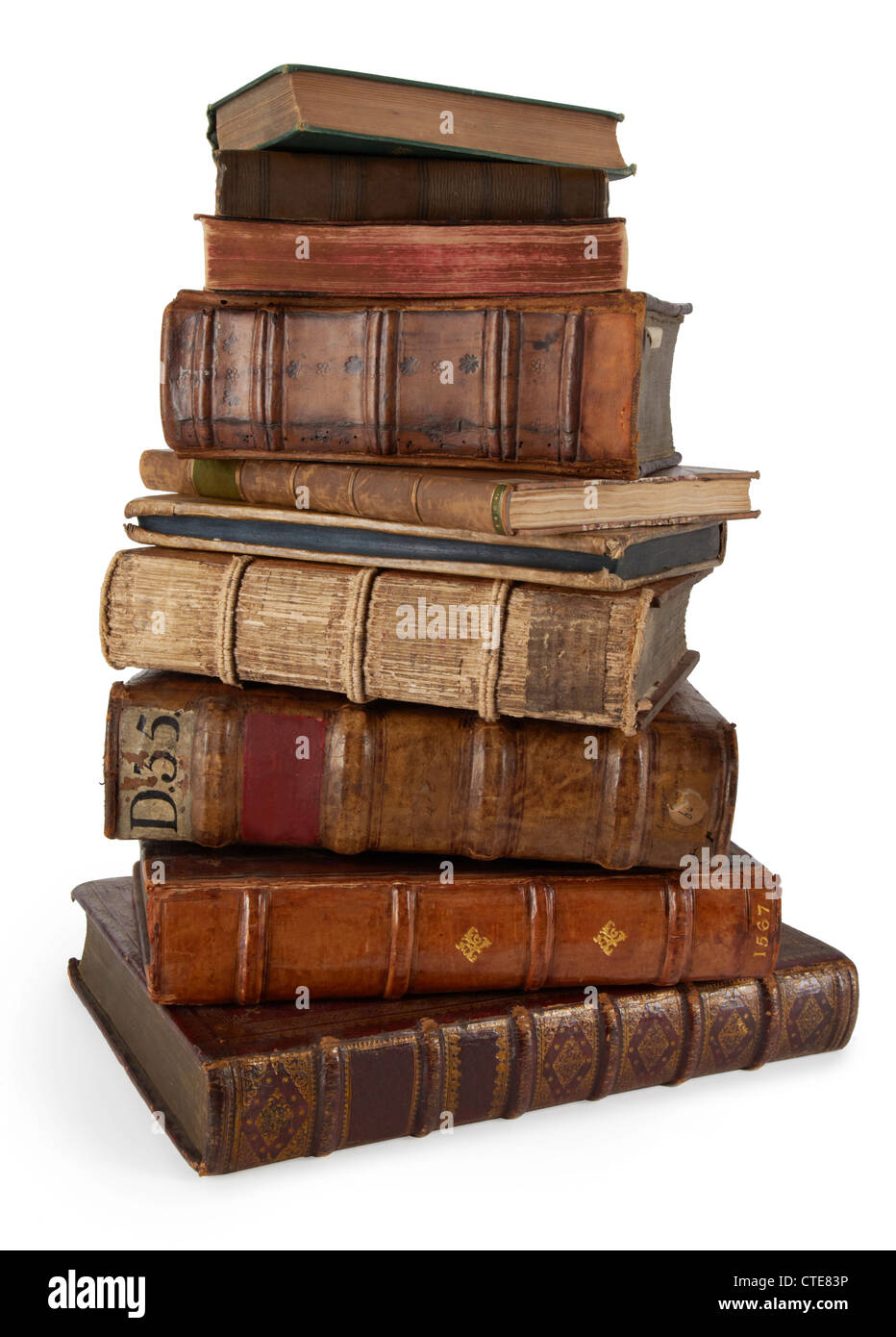 a tall stack of twisting old books varying in shape size and colour on a clean white background Stock Photo