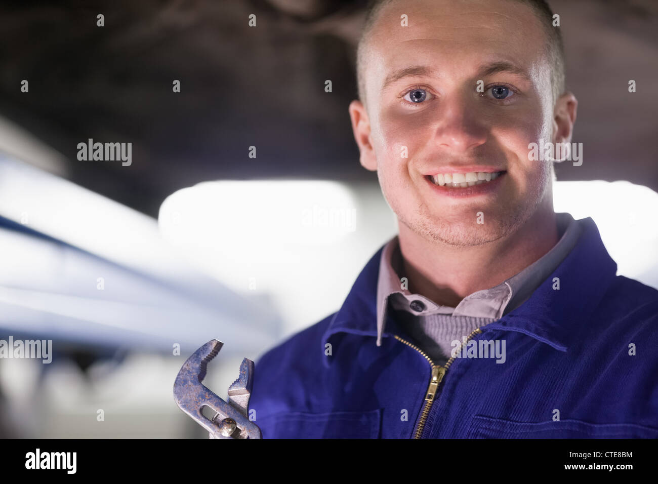 Mechanic holding an adjustable pliers while looking at camera Stock