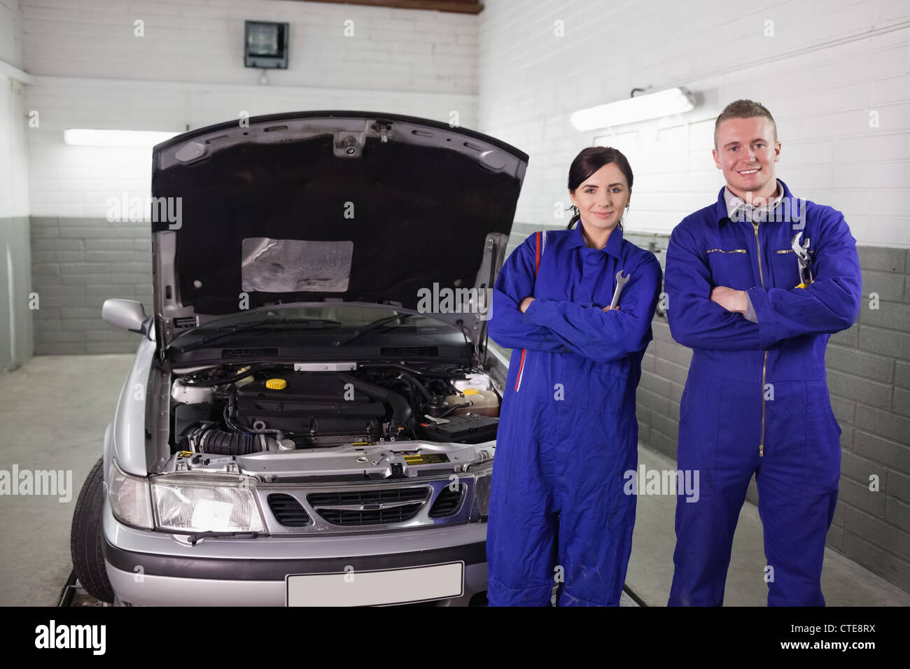 Mechanics next to a car Stock Photo - Alamy