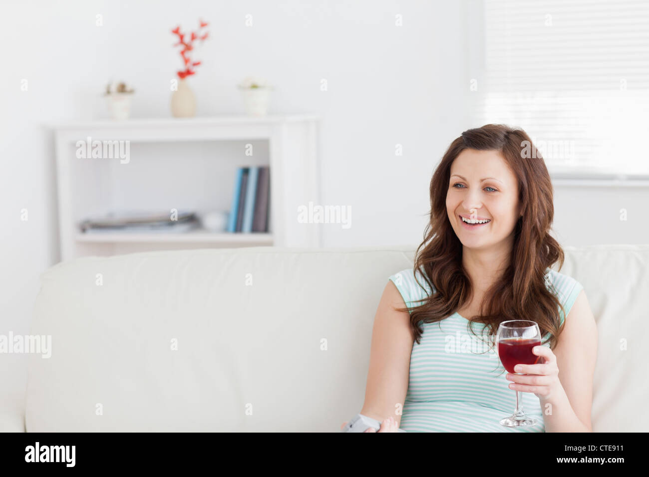 Woman smiling while holding a glass of wine Stock Photo - Alamy