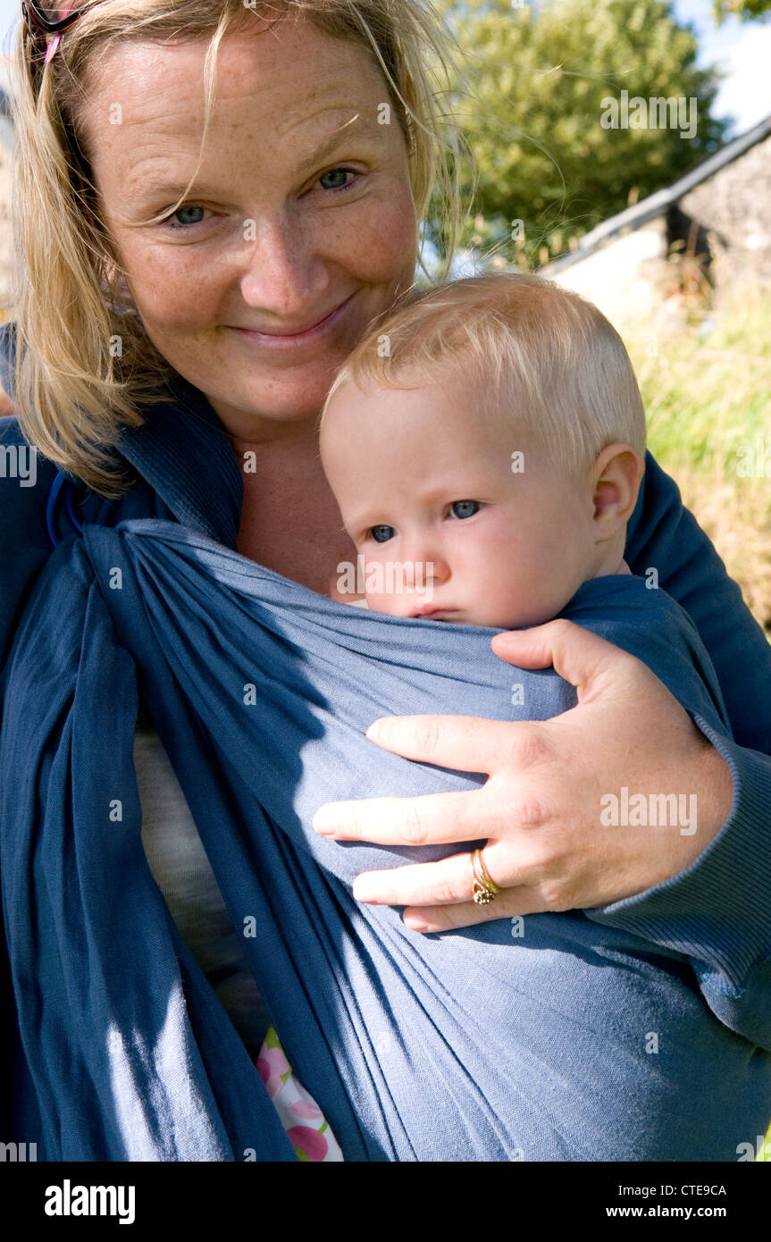 Woman carrying a baby in a baby sling Stock Photo Alamy